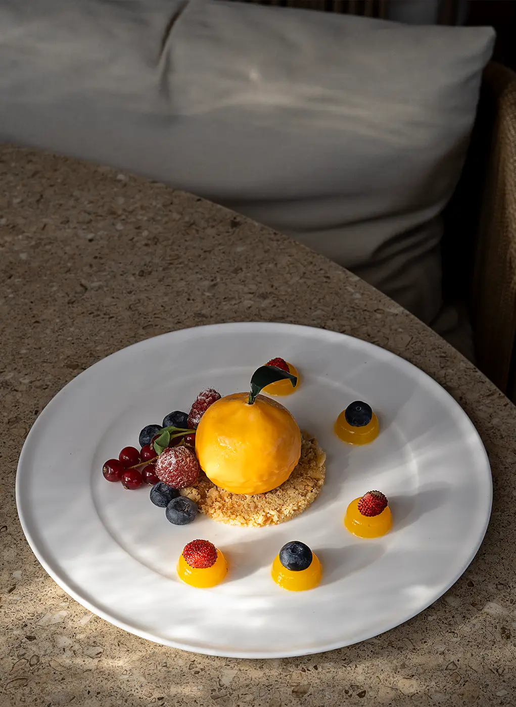 Dessert gourmet a forma di agrume su base croccante con frutti di bosco, servito al ristorante di Villa Athena Resort.